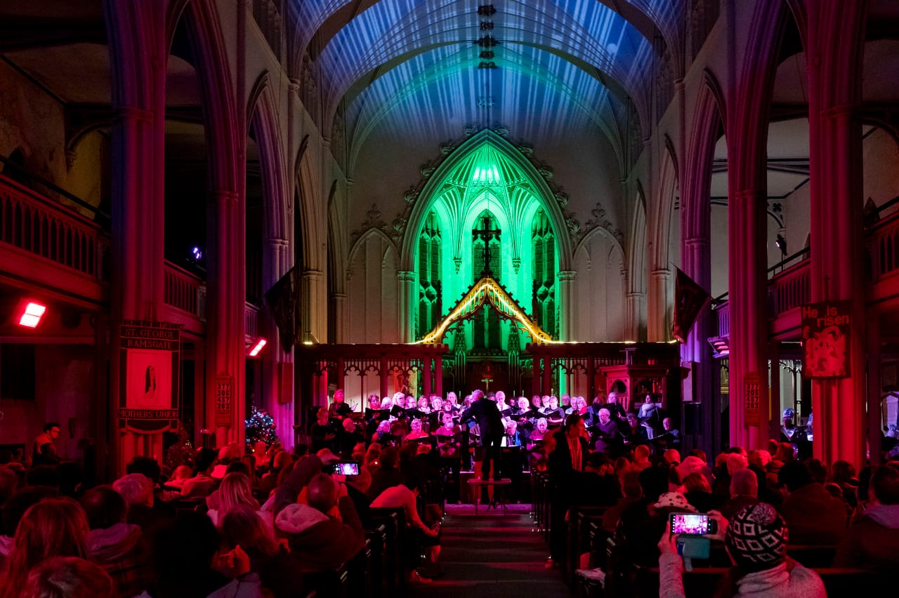 People watch live music in an illuminated church
