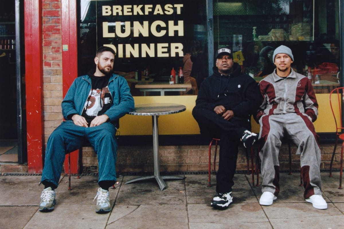 Three men sit outside a cafe