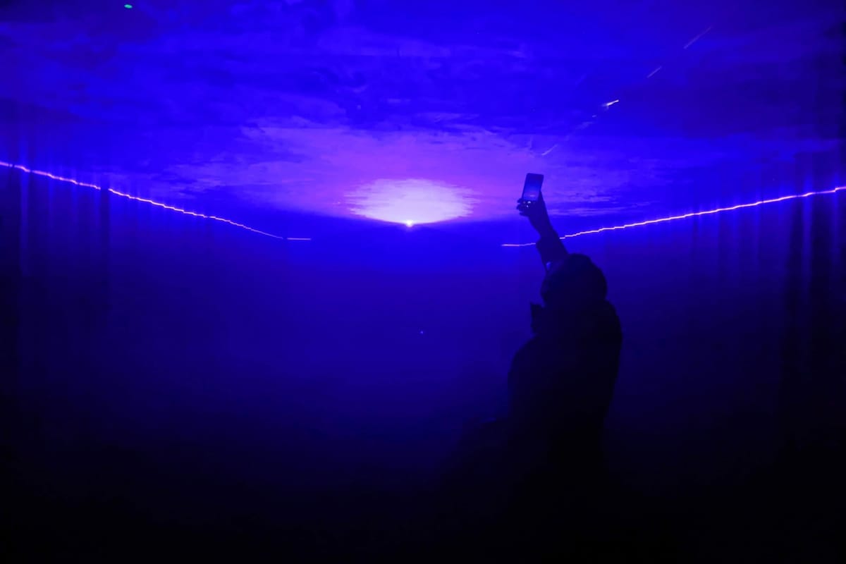 A person takes a photo of a light projection