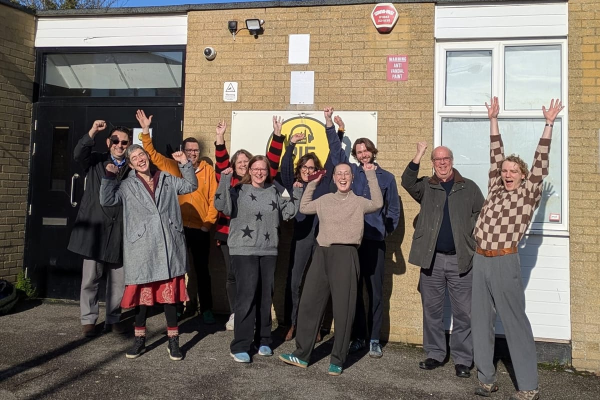 A group of people celebrate outside a building
