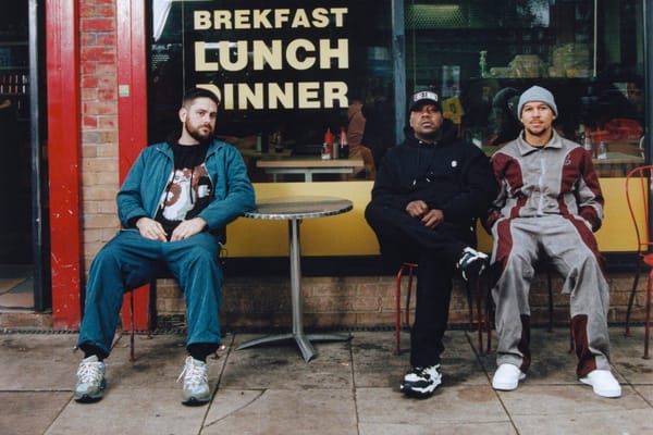 Three men sit outside a cafe